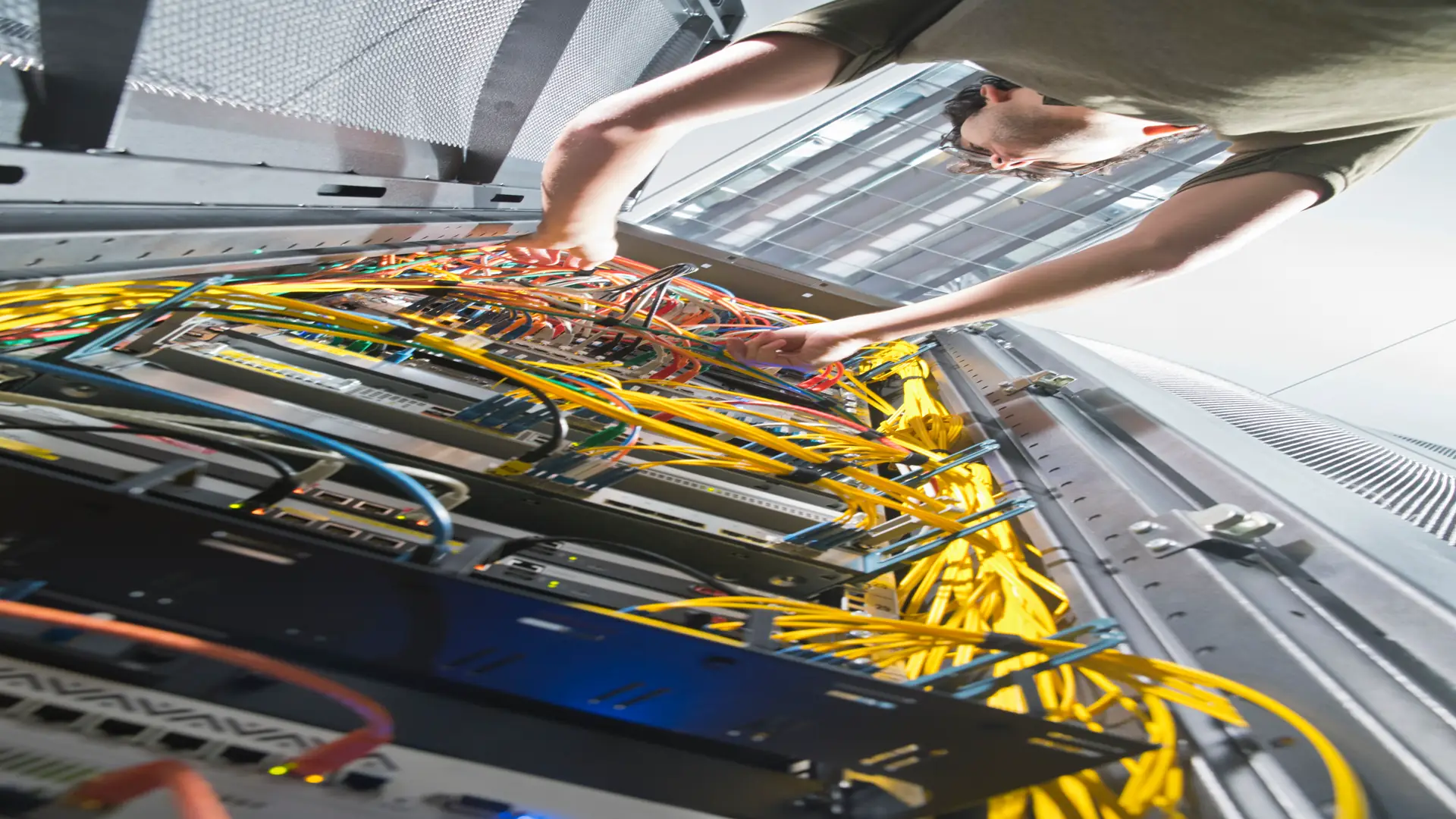 Low angle shot of technician inspecting server wiring