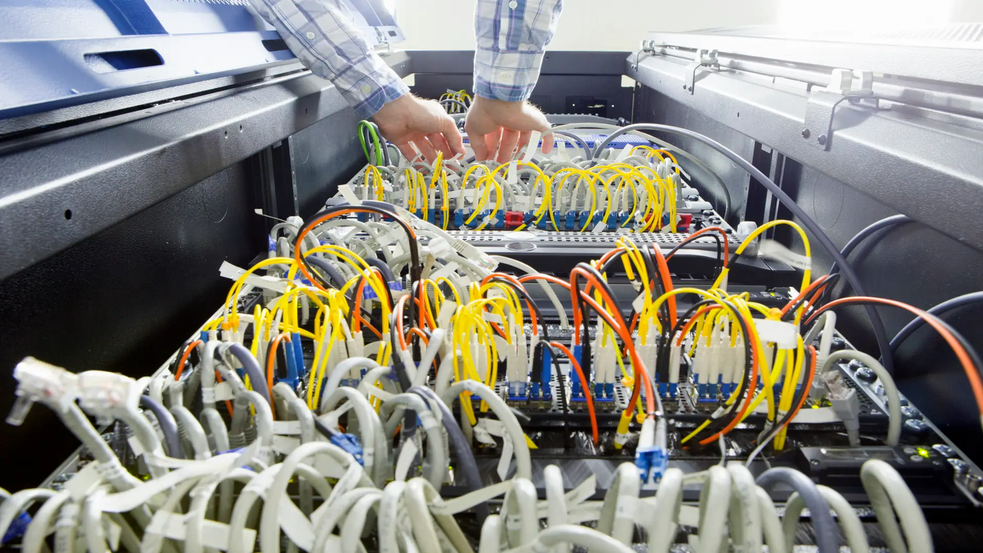 Low angle shot of server full of wires being checked