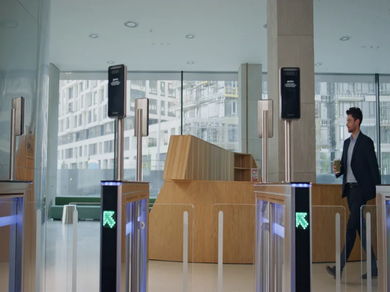 Employee walking through automatic gates with coffee