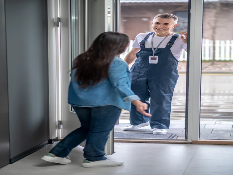 Woman inviting worker at home entrance