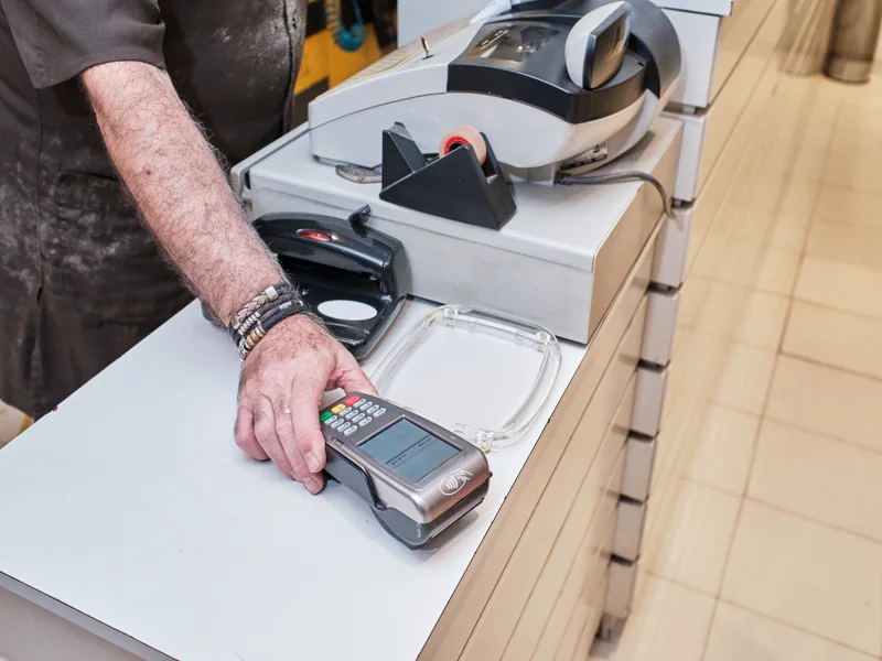 Worker managing ATM terminal in retail store