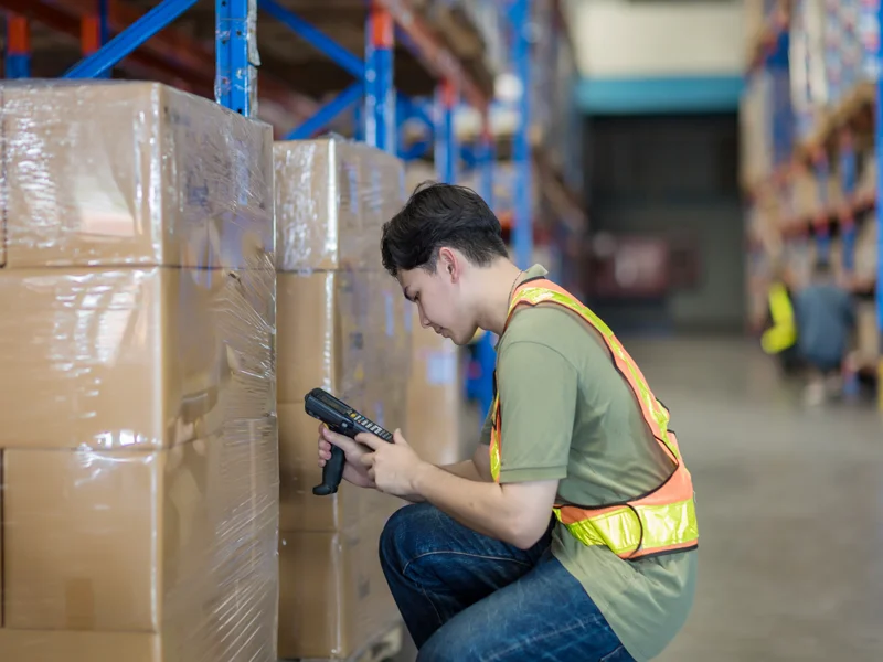 Warehouse worker organizing inventory on storage racks
