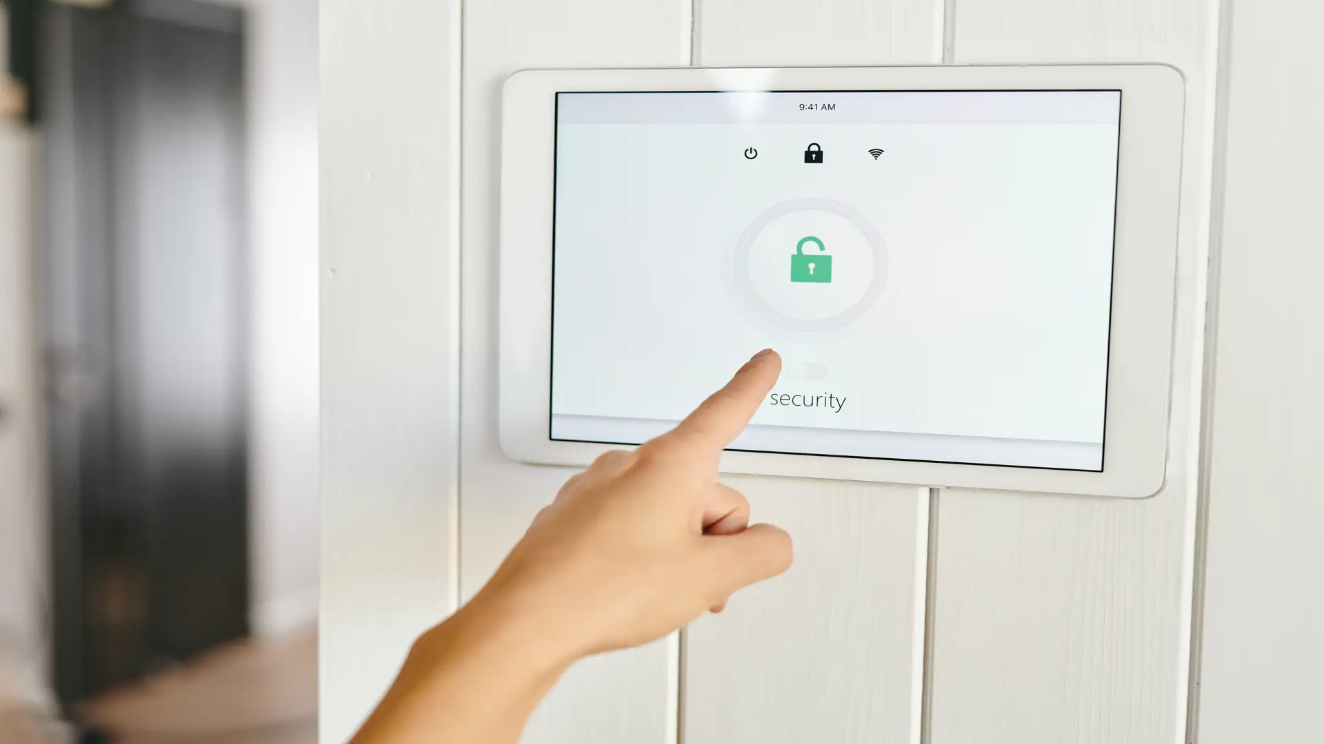 Hand pointing at home security alarm control panel