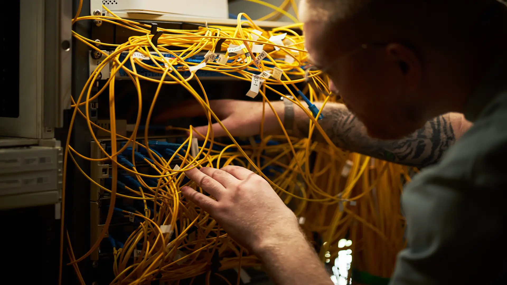 Technician testing network cables in server room